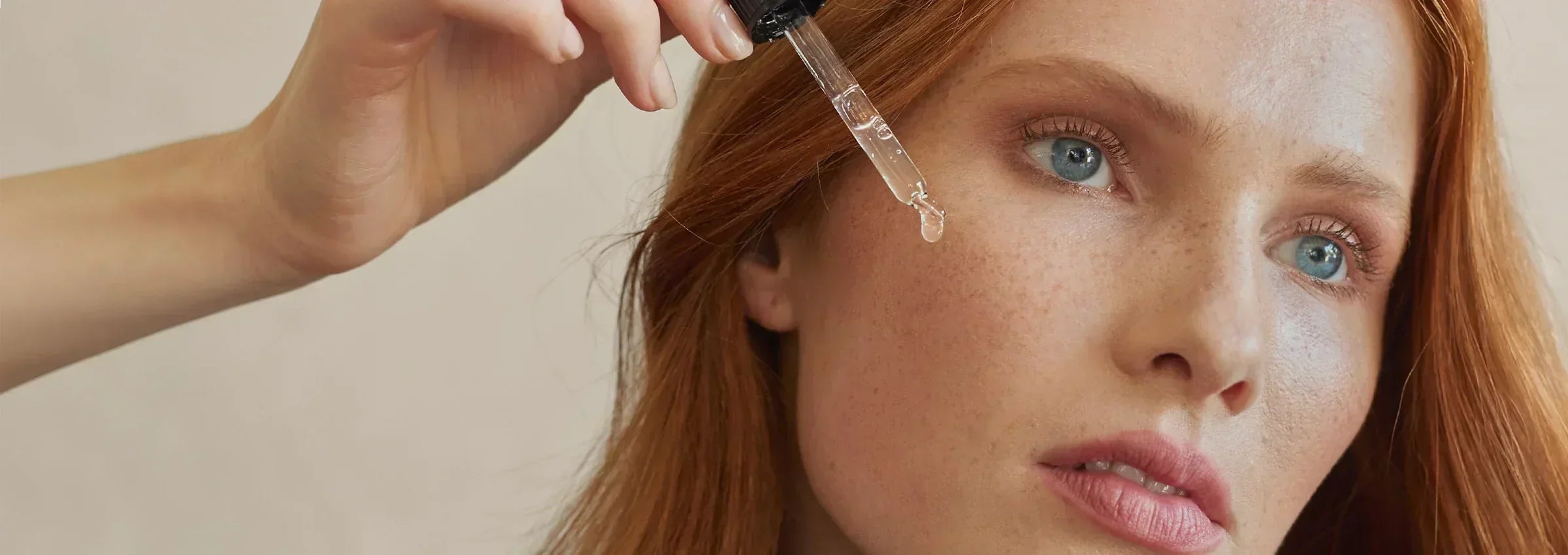 Woman applies serum to the face with a pipette