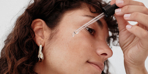 Woman applies serum to the face with a pipette