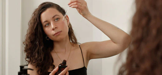 Woman applies serum to the face with a pipette