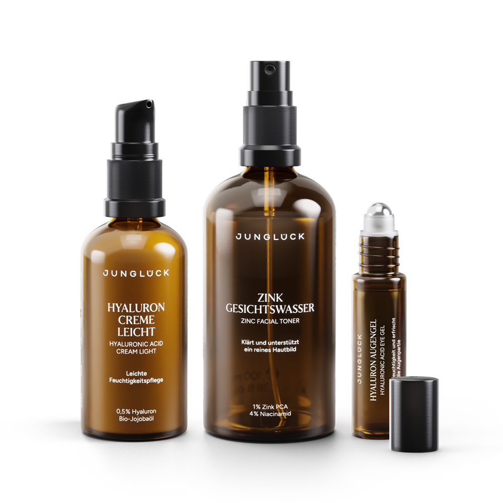 A set consisting of three JUNGLÜCK products: a Hyaluron cream Light in an amber glass bottle, a Zinc