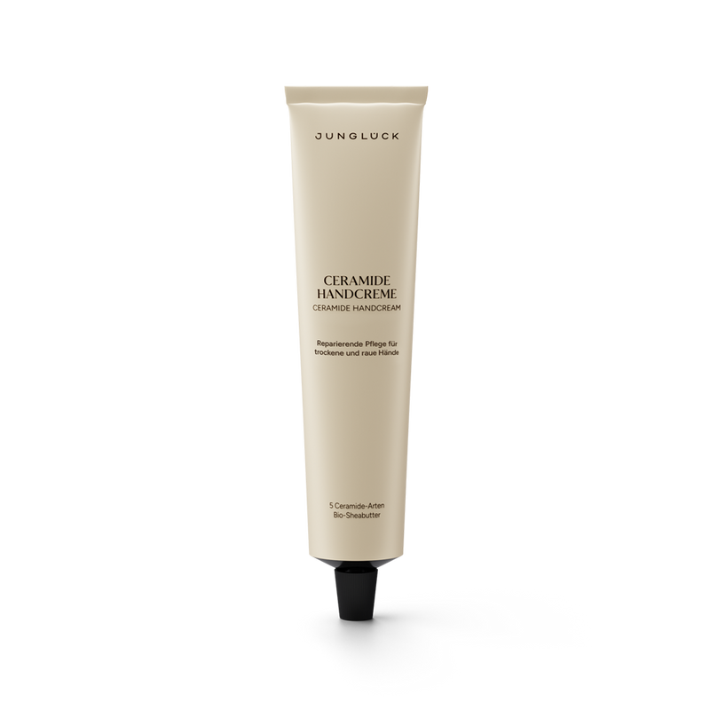 Beige tube of Junglück Ceramide Handcreme with black cap and black text detailing ceramide skincare benefits.
