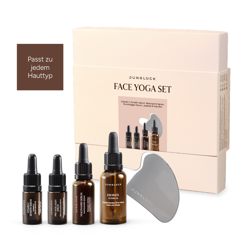 JUNGLÜCK Face Yoga Set Geschenkset mit vier Braunglasflaschen und einem Gua Sha Werkzeug. Verpackung in sanften Farben.
