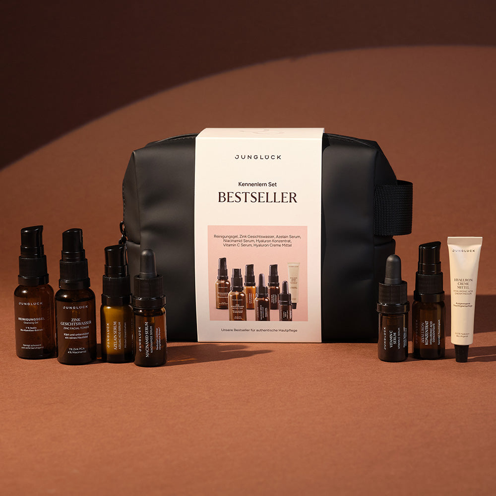 Bestseller-kennismakingsset met verschillende bruine glazen flesjes voor gezichtsreiniging en -Verzorging, verpakt in een zwarte tas.