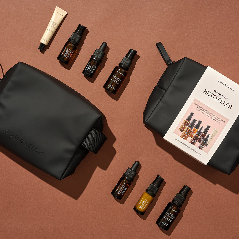 Kennismakingssets met bestsellerproducten van JUNGLÜCK in elegante, zwarte make-uptasjes.