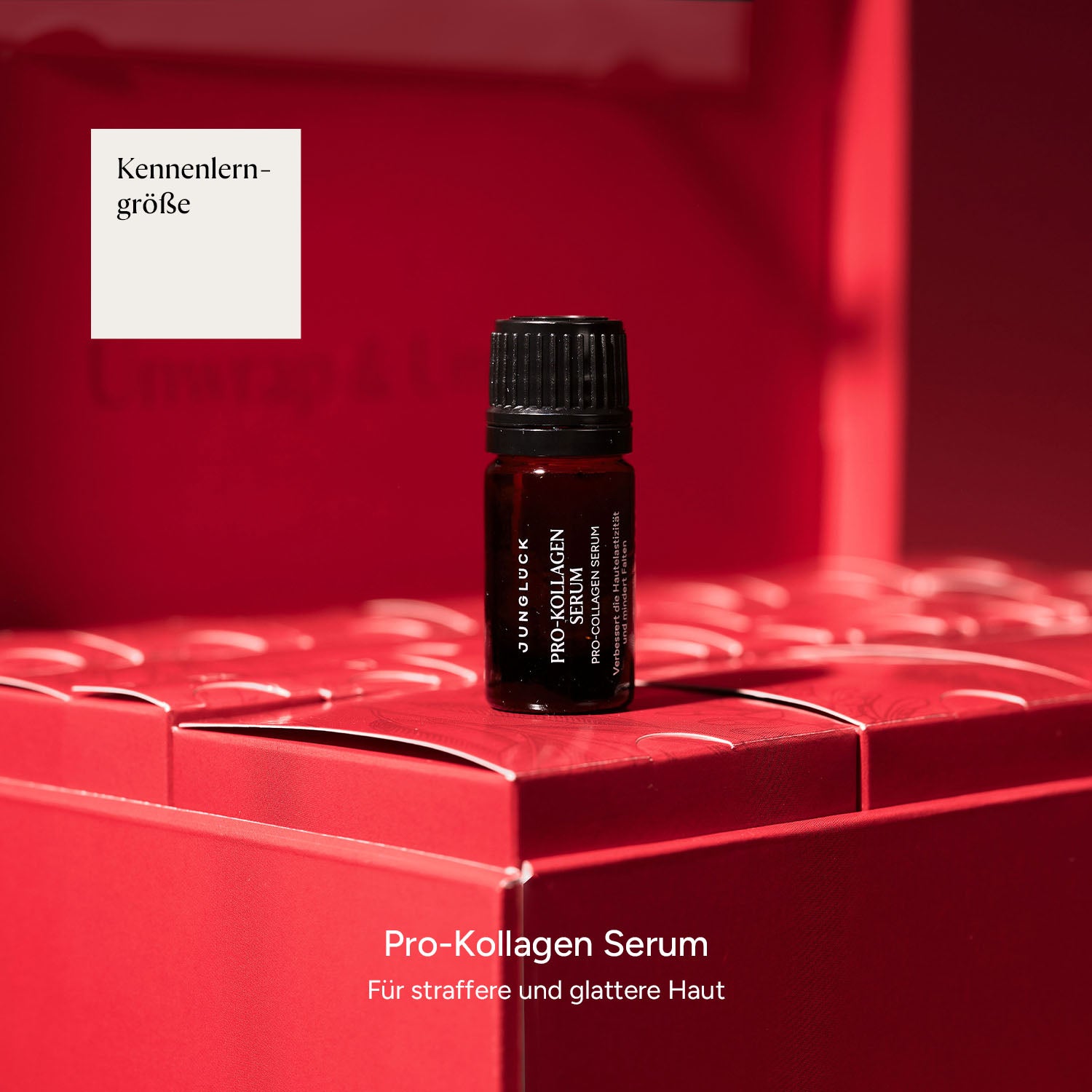 Braunglasflasche mit Pro-Kollagen Serum vor rotem Hintergrund, umgeben von Paketen.