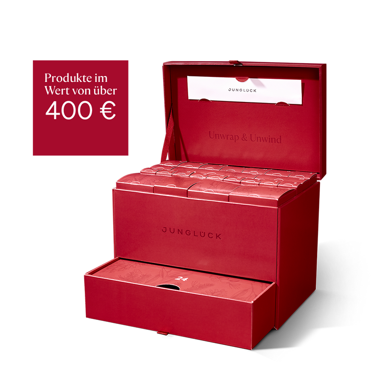 Rote Geschenkbox von JUNGLÜCK, geöffnet und gefüllt mit 24 Produkten. Hinweis auf Warenwert über 400 €.