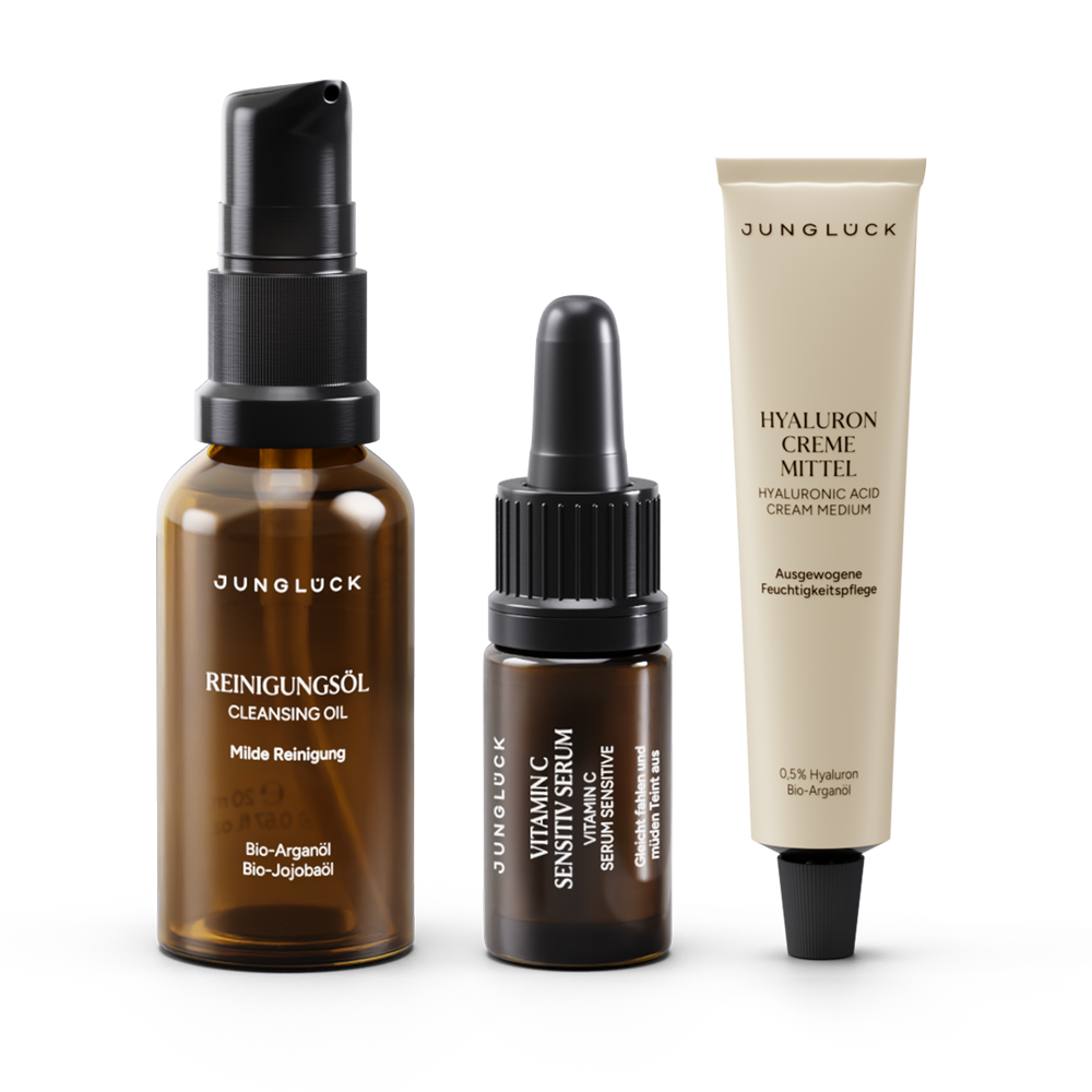 Three JUNGLÜCK products in amber glass bottles: Cleansing Oil, Vitamin Sensitive serum, and Hyaluron cream . Skin care set.